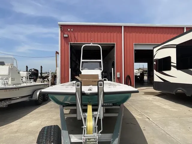 Slide: The Image of 2025 Majek 2206 Illusion boat on trailer outside red building. - 2