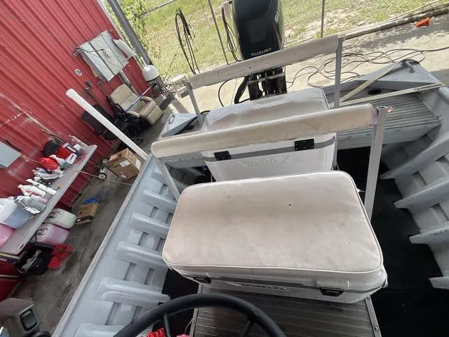 Slide: The Image of 2000 Alumacraft boat interior with seating and motor, parked in a garage. - 12