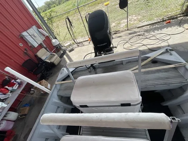 Slide: The Image of 2000 Alumacraft boat interior with motor, seats, and storage in a garage setting. - 13