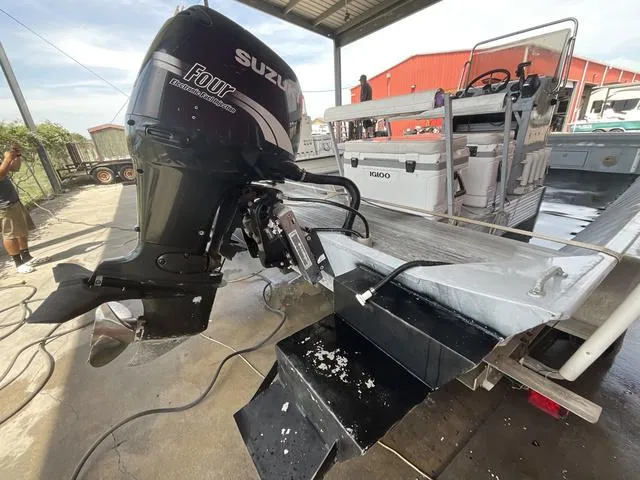 Slide: The Image of Alumacraft boat with Suzuki outboard motor, 2000 model, in a covered dock area. - 4