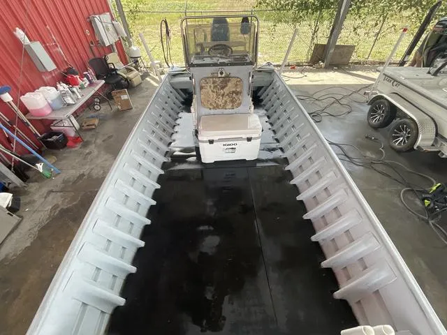 Slide: The Image of 2000 Alumacraft boat interior with central console and storage, parked in a garage. - 8