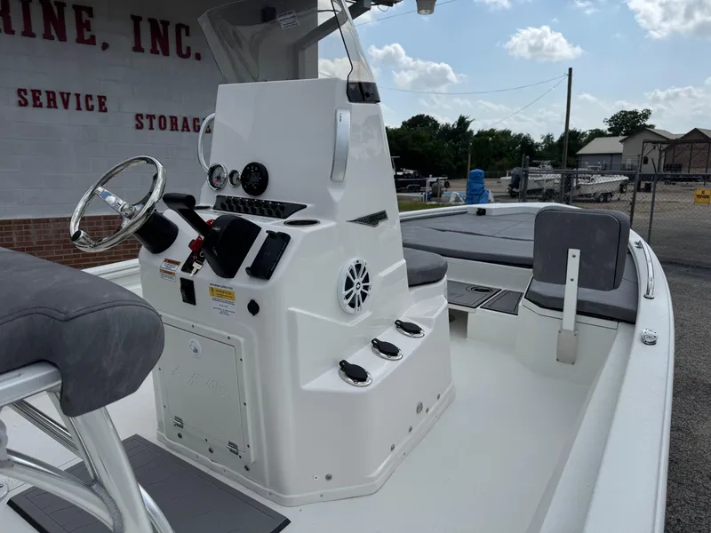 Slide: The Image of Avid 21 Fusion 2025 boat with sleek console and seating, docked outdoors. - 13