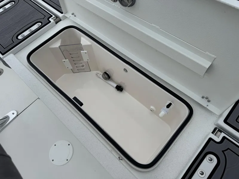 Slide: The Image of Open storage compartment on 2025 Avid 21 Fusion boat deck. - 16