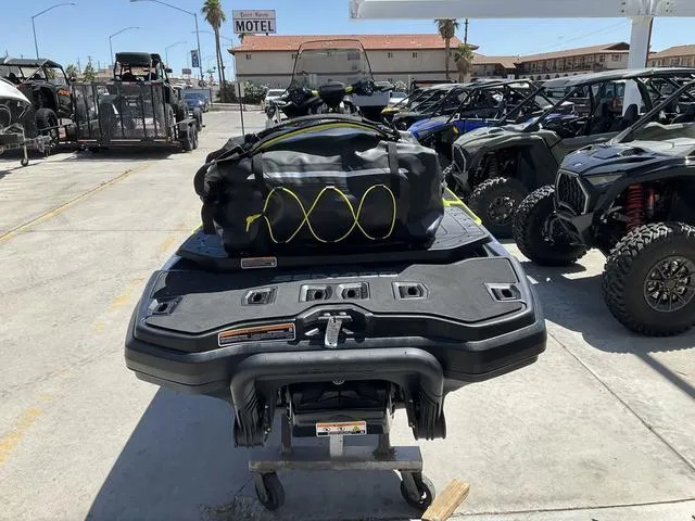 Slide: The Image of 2025 Sea-Doo Waverunner Explorer Pro with gear bag, parked among off-road vehicles. - 5