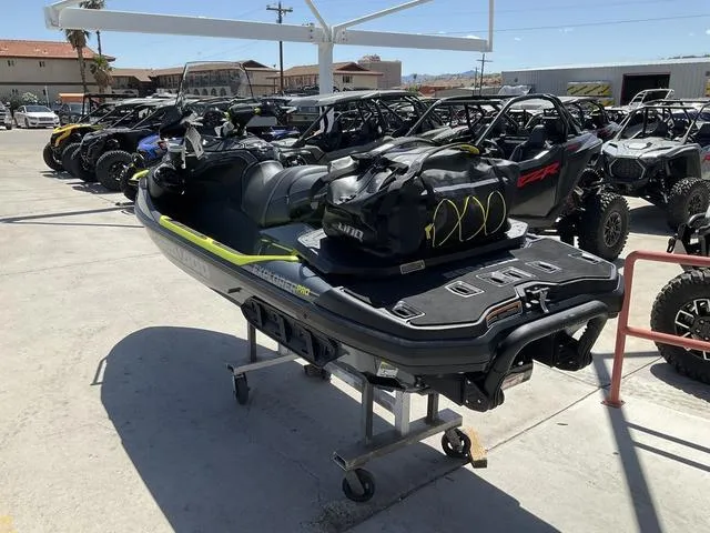 Slide: The Image of 2025 Sea-Doo Waverunner Explorer Pro on display with gear bag, surrounded by off-road vehicles. - 7