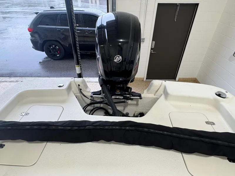 Slide: The Image of 2017 Carolina Skiff 19 LS boat with outboard motor in a garage setting. - 12