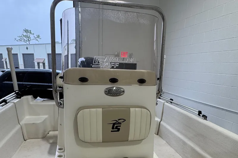 Slide: The Image of 2017 Carolina Skiff 19 LS boat console with windshield and seating in a garage setting. - 8
