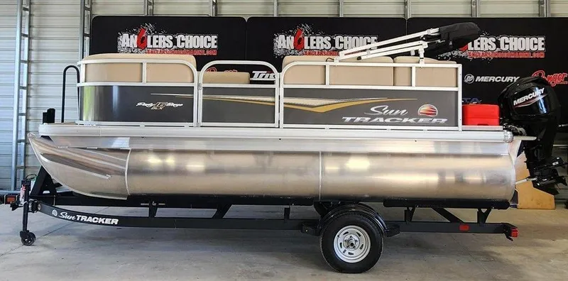 The Image of 2025 Sun Tracker PARTY BARGE® 16 DLX pontoon boat on trailer in showroom. - 0