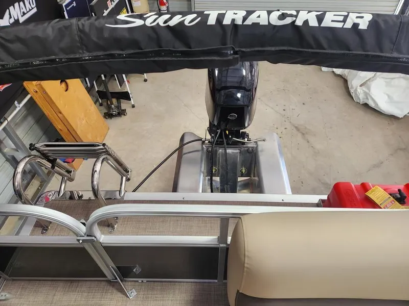 Slide: The Image of 2025 Sun Tracker PARTY BARGE® 16 DLX pontoon boat interior with motor and seating. - 2