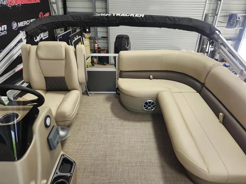 Slide: The Image of 2025 Sun Tracker PARTY BARGE® 16 DLX interior with beige seating and modern helm. - 4