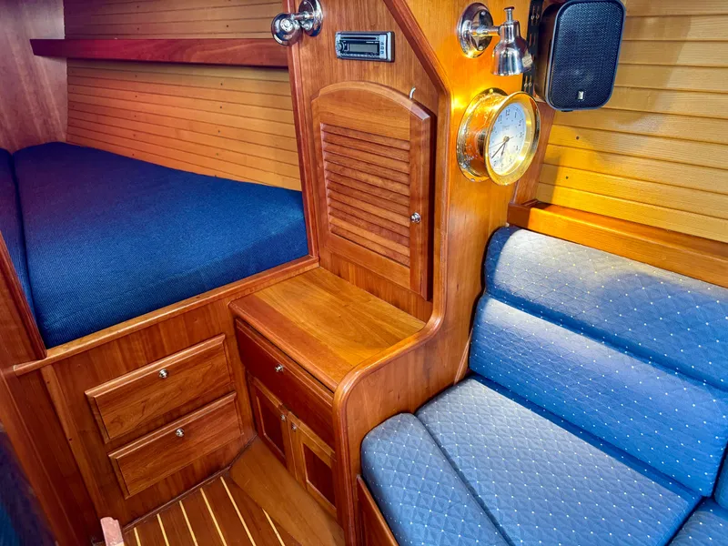Slide: The Image of 2007 Sabre Spirit yacht interior with wooden cabinetry, blue upholstery, and nautical clock. - 10
