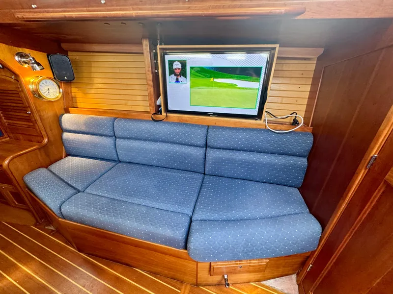 Slide: The Image of 2007 Sabre Spirit yacht interior with blue cushioned seating and wall-mounted TV. - 15
