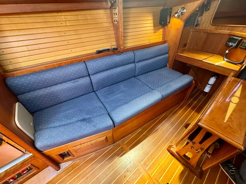Slide: The Image of 2007 Sabre Spirit yacht interior with blue cushioned seating and wooden paneling. - 23