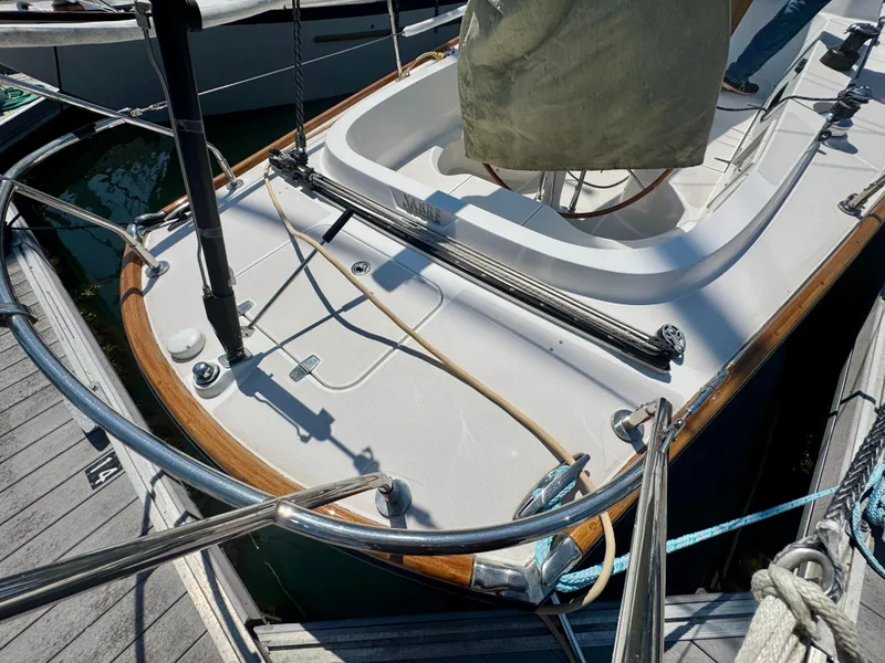 Slide: The Image of 2007 Sabre Spirit sailboat deck with wooden trim and metal railings at dock. - 26