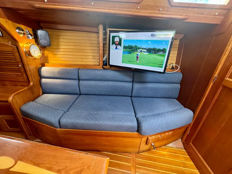 Slide: The Image of 2007 Sabre Spirit yacht interior with blue cushioned seating and mounted TV. - 5