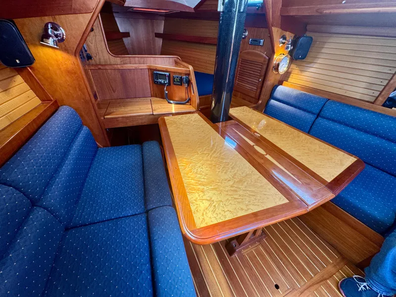 Slide: The Image of 2007 Sabre Spirit yacht interior with blue seating and wooden table. - 6