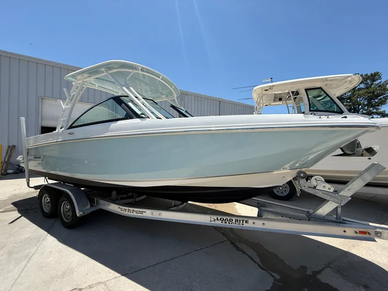 Slide: The Image of 2020 Boston Whaler 230 Vantage boat on trailer, parked outdoors under clear sky. - 0