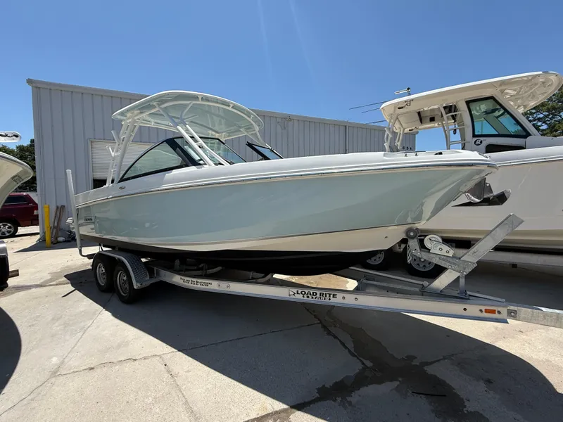 Slide: The Image of 2020 Boston Whaler 230 Vantage boat on trailer, parked outdoors under clear sky. - 1