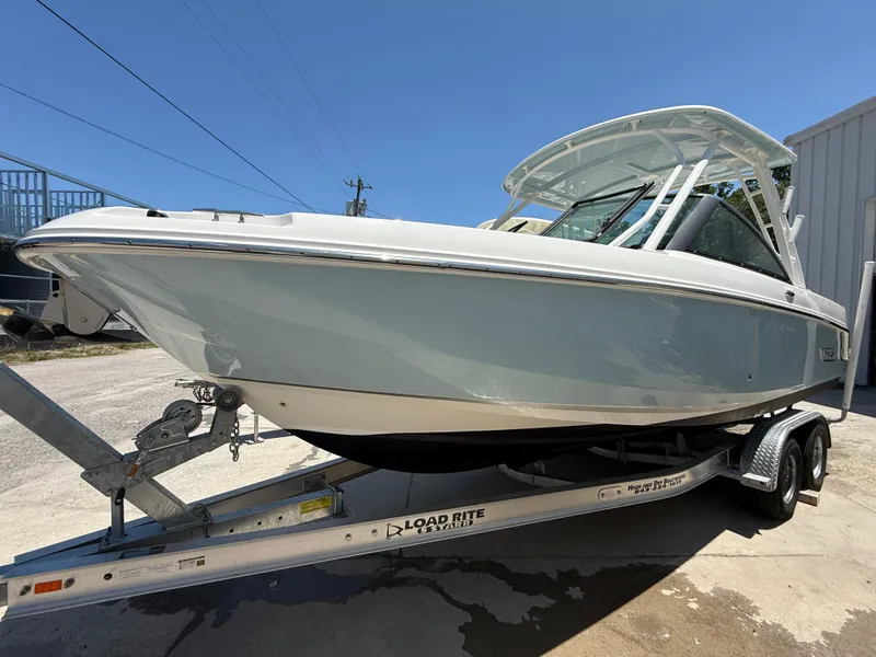 Slide: The Image of 2020 Boston Whaler 230 Vantage boat on trailer, side view, under clear blue sky. - 10