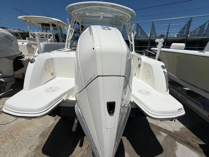 Slide: The Image of 2020 Boston Whaler 230 Vantage boat, rear view, docked under clear blue sky. - 13