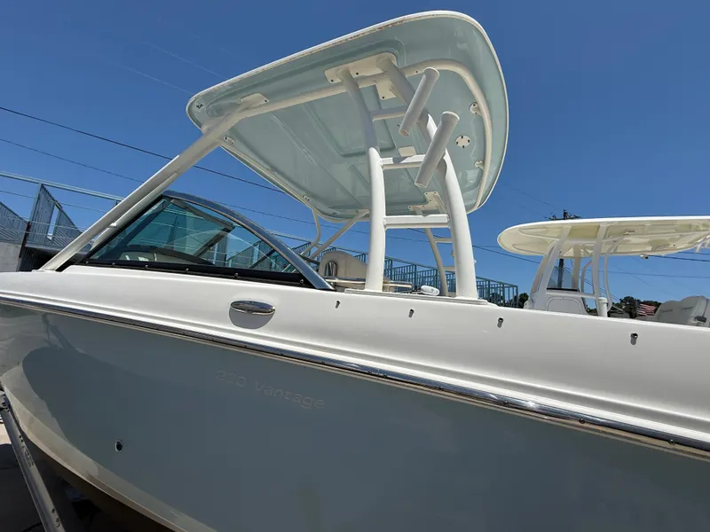 Slide: The Image of 2020 Boston Whaler 230 Vantage boat with sleek design and sturdy structure under clear blue sky. - 15