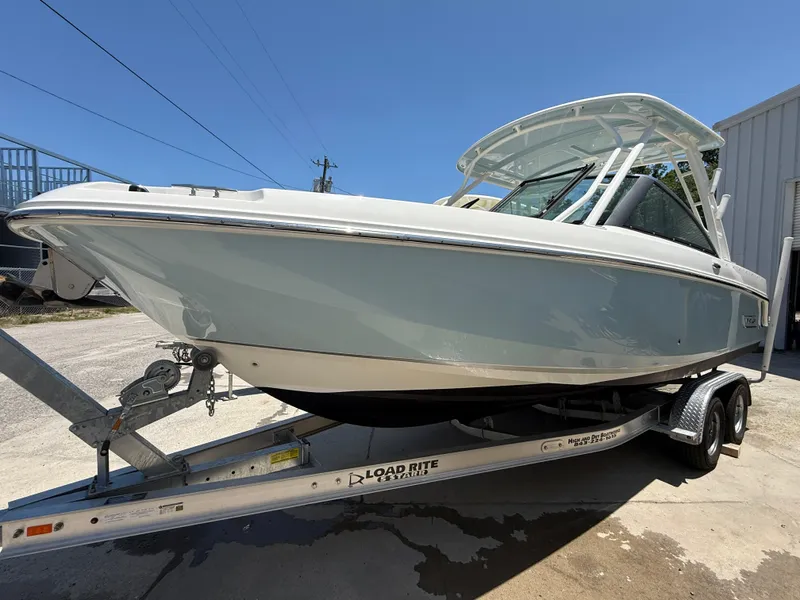 Slide: The Image of 2020 Boston Whaler 230 Vantage boat on a trailer, parked outdoors. - 16
