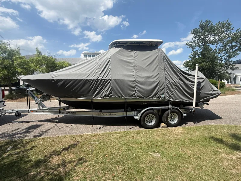 Slide: The Image of 2020 Boston Whaler 230 Vantage boat covered on a trailer, parked outdoors. - 18