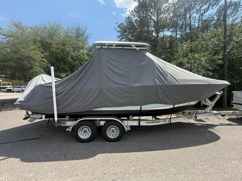 Slide: The Image of 2020 Boston Whaler 230 Vantage boat covered on a trailer, parked outdoors. - 19