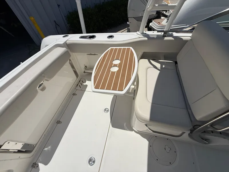 Slide: The Image of 2020 Boston Whaler 230 Vantage boat interior with seating and wooden table. - 24