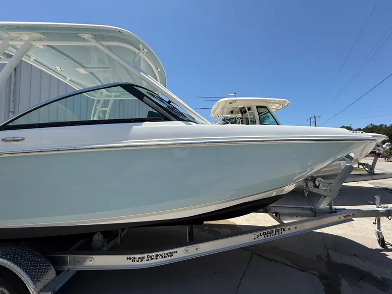 Slide: The Image of 2020 Boston Whaler 230 Vantage boat on trailer, side view under clear blue sky. - 3