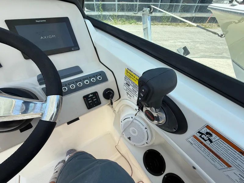 Slide: The Image of 2020 Boston Whaler 230 Vantage helm with steering wheel, controls, and display screen. - 36