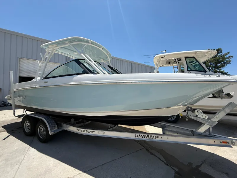 Slide: The Image of 2020 Boston Whaler 230 Vantage boat on trailer, parked outdoors under clear blue sky. - 7
