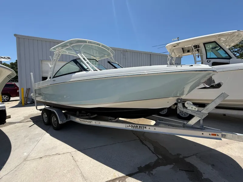 Slide: The Image of 2020 Boston Whaler 230 Vantage boat on trailer, parked outdoors under clear sky. - 9