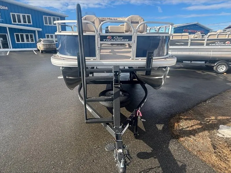 Slide: The Image of 2025 Sun Tracker BB 18 DLX pontoon boat on trailer in dealership lot. - 4