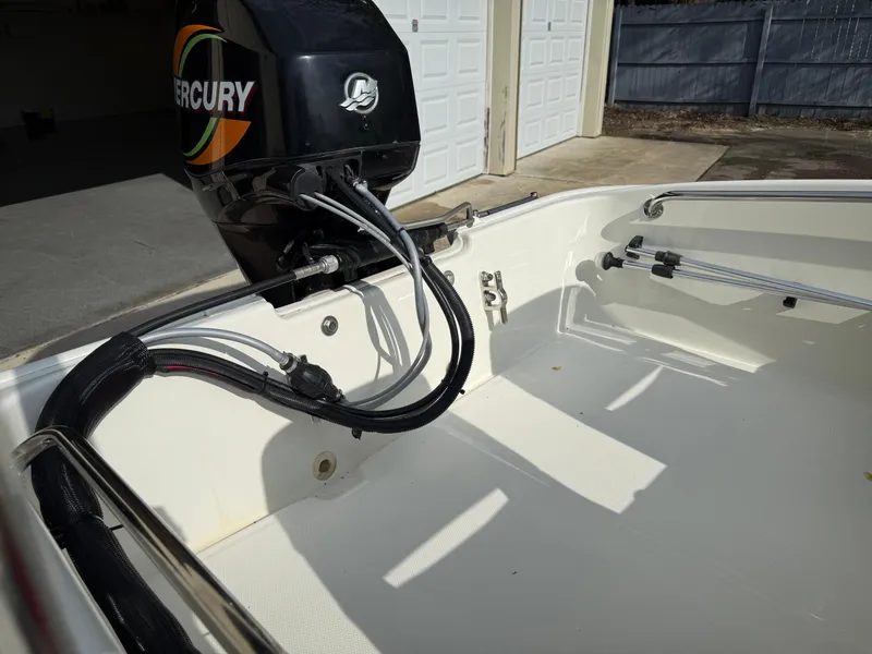 Slide: The Image of 2009 Boston Whaler 130 Super Sport boat with Mercury engine, parked near garage. - 12