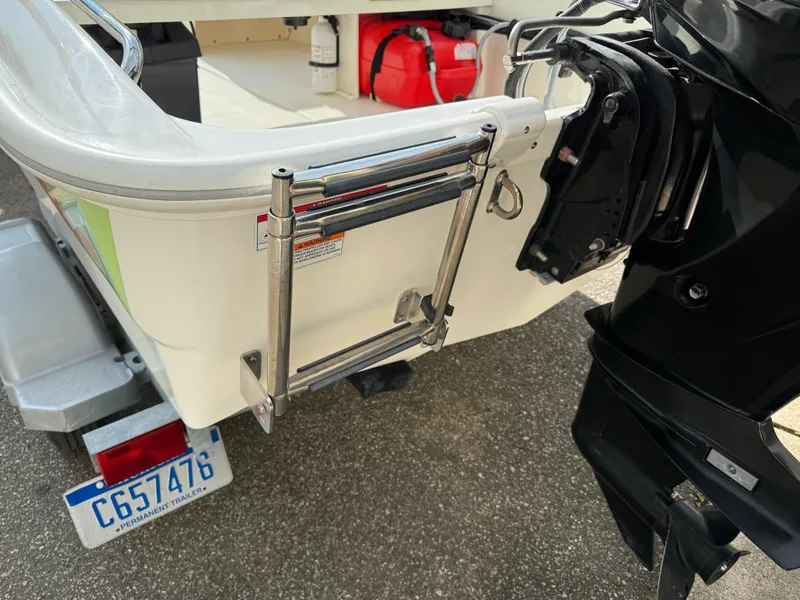 Slide: The Image of 2009 Boston Whaler 130 Super Sport boat with motor and ladder, parked on trailer. - 13