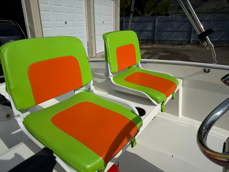 Slide: The Image of 2009 Boston Whaler 130 Super Sport with vibrant green and orange seating. - 7
