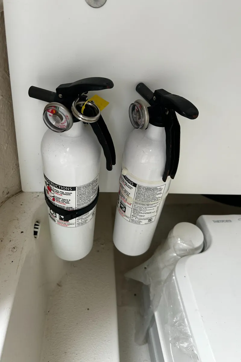 Slide: The Image of Two white fire extinguishers mounted on a NauticStar 25 XS Offshore boat. - 27