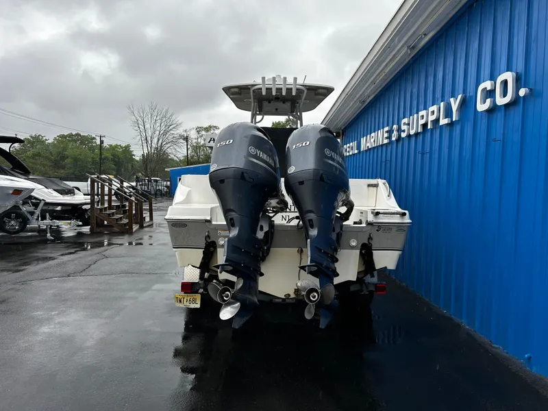 Slide: The Image of 2018 NauticStar 25 XS Offshore boat with twin Yamaha engines at a marine supply store. - 4