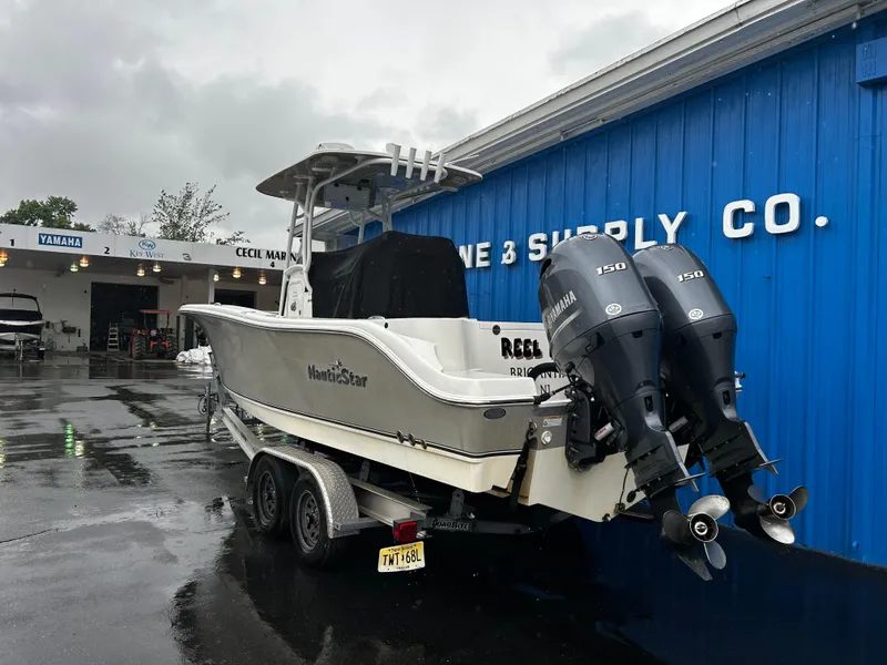 Slide: The Image of 2018 NauticStar 25 XS Offshore boat with twin Yamaha engines at a marine supply store. - 5