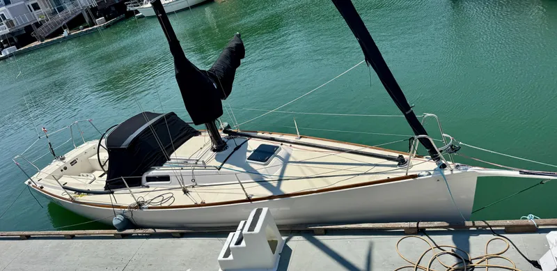 Slide: The Image of 2005 J Boats J/100 sailboat docked in a marina, featuring sleek design and covered sails. - 13