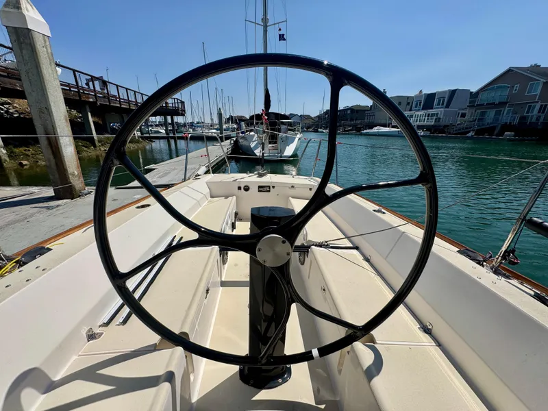 Slide: The Image of 2005 J Boats J/100 sailboat cockpit with steering wheel, docked in a marina. - 14