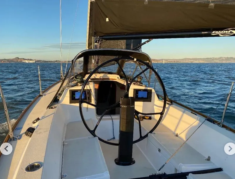 Slide: The Image of 2005 J Boats J/100 sailboat cockpit with steering wheel on open water. - 2