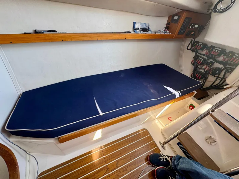 Slide: The Image of Interior of 2005 J Boats J/100 sailboat with blue cushioned bench and wooden accents. - 20