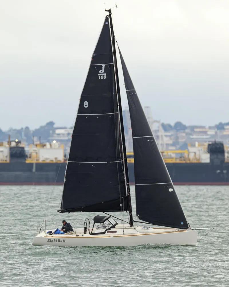 Slide: The Image of 2005 J Boats J/100 sailboat with black sails on the water. - 5