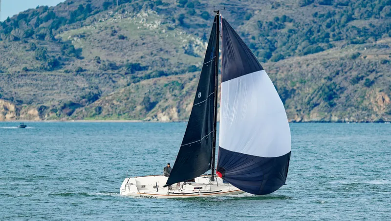 Slide: The Image of 2005 J Boats J/100 sailing on a scenic lake with hills in the background. - 7