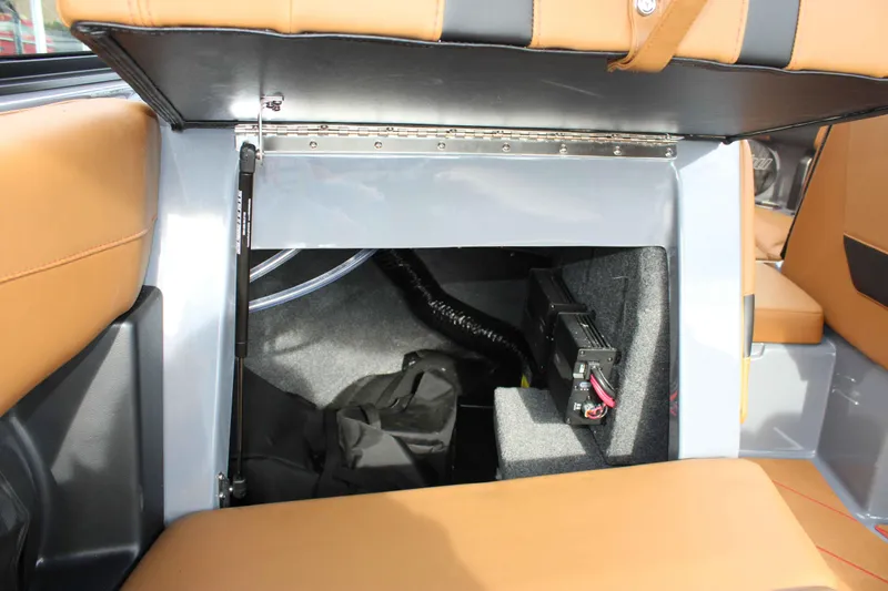 Slide: The Image of 2025 Malibu Wakesetter 22 LSV storage compartment with tan upholstery and interior components. - 15