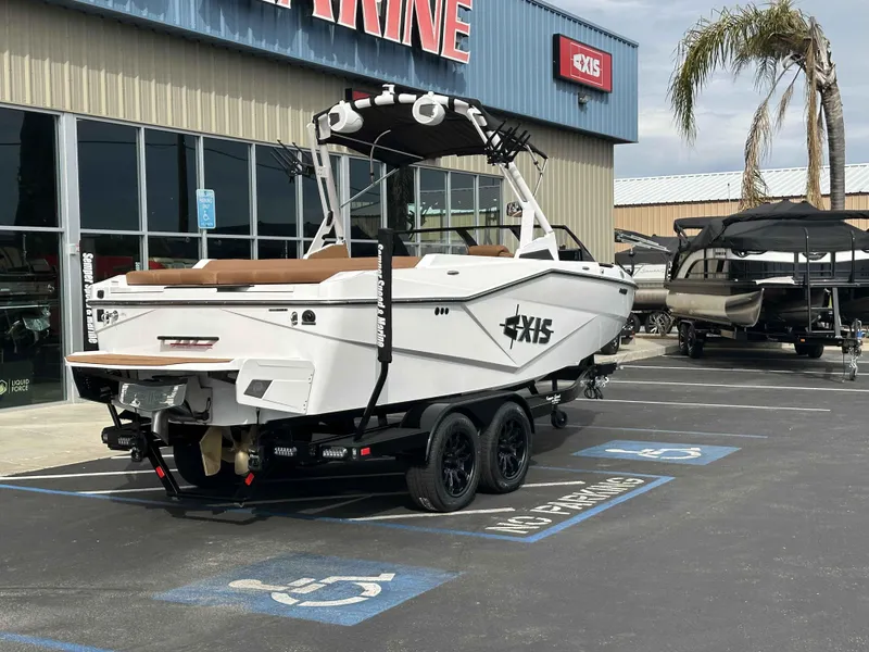 Slide: The Image of 2025 Axis T220 boat parked outside a marine dealership, showcasing sleek design and modern features. - 3