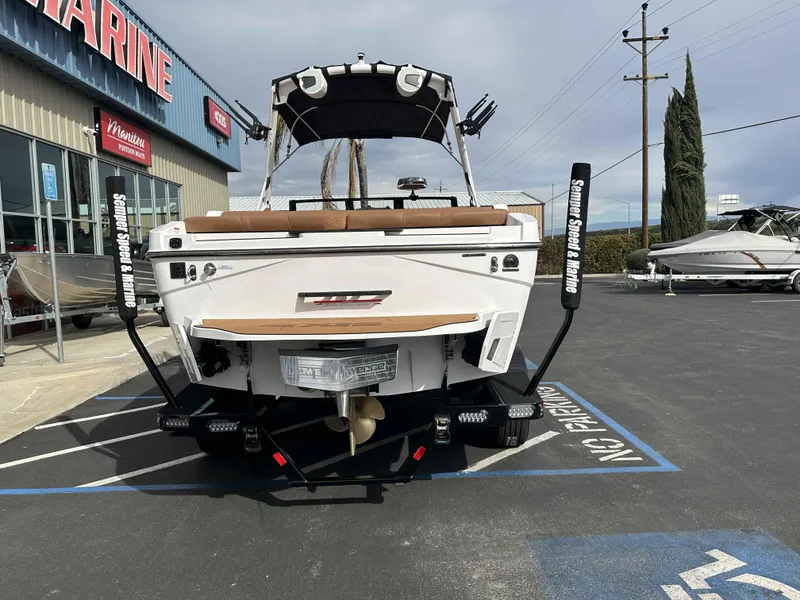Slide: The Image of 2025 Axis T220 boat at a marine dealership, rear view. - 4