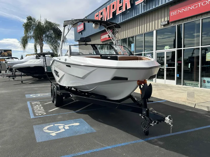Slide: The Image of 2025 Axis T220 boat on trailer outside dealership, parked in a handicap spot. - 5